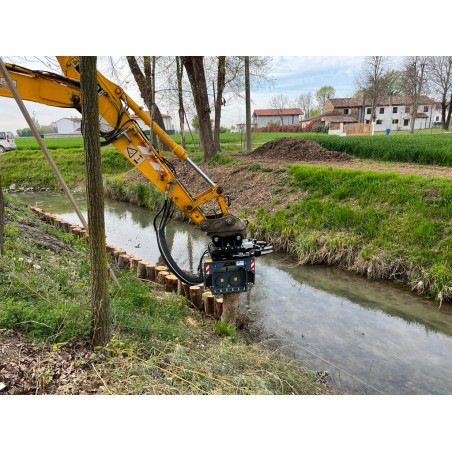 Enfonce-pieux hydraulique en action pour renforcement de berge.